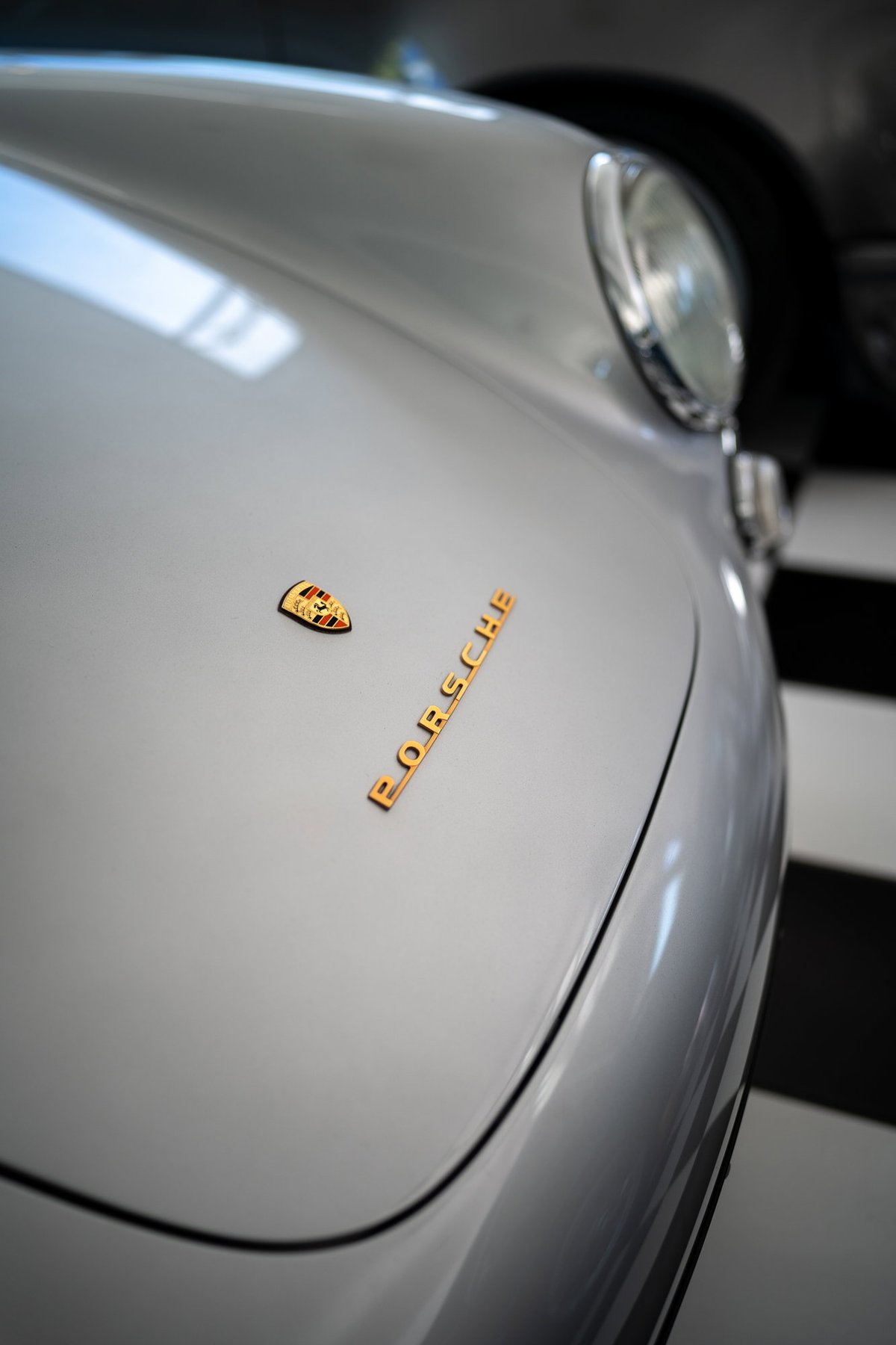 Silver Porsche 356 with gold badging on the hood.