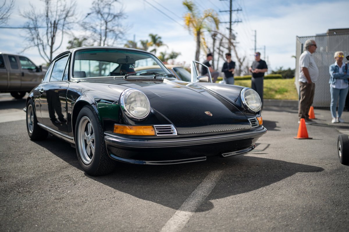 1970s Porsche 911 coupe in black, featuring chrome trim and classic rims.