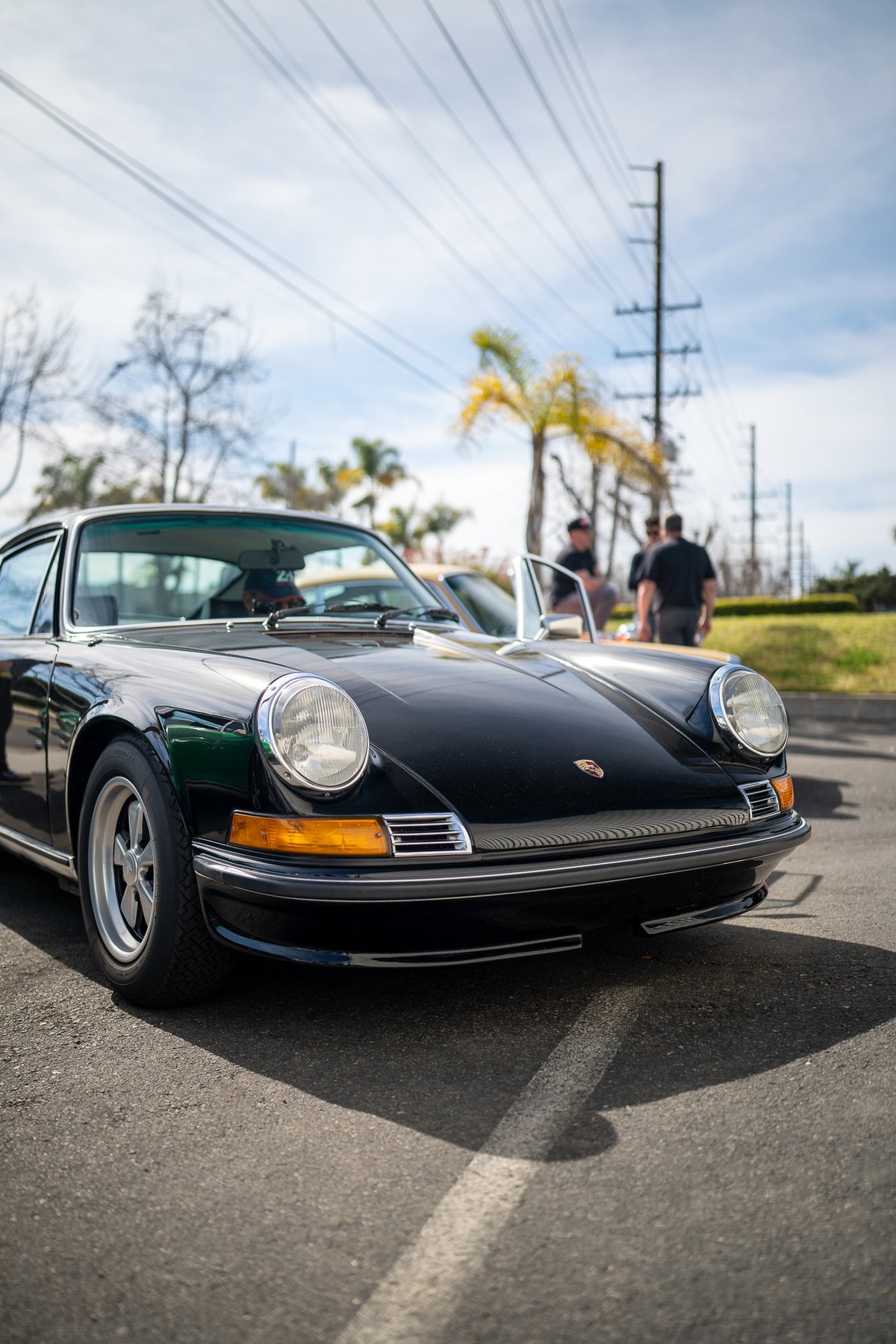 Black Porsche 911 with chrome trim and Fuchs rims.
