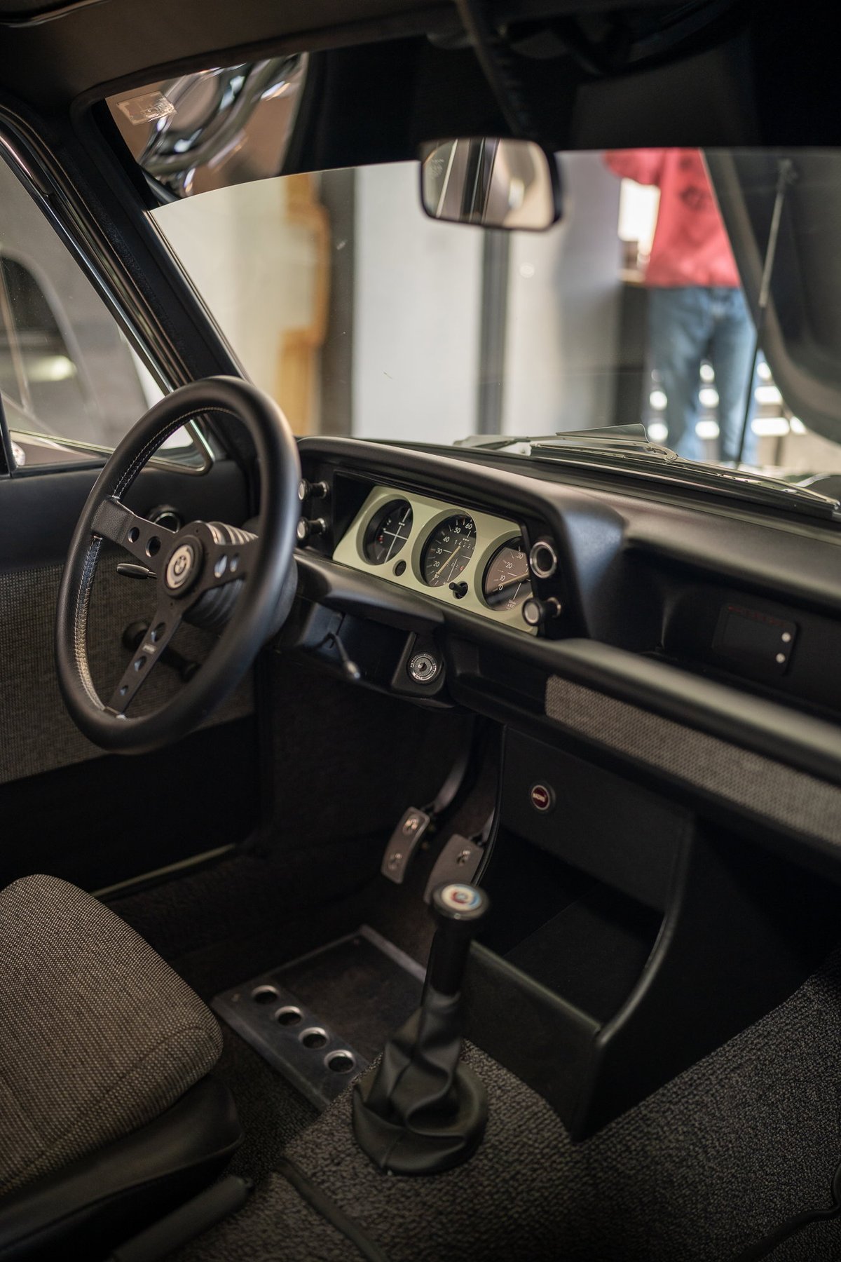 BMW 2002tii interior, featuring a vintage steering wheel, shift knob, and dashboard gauges.