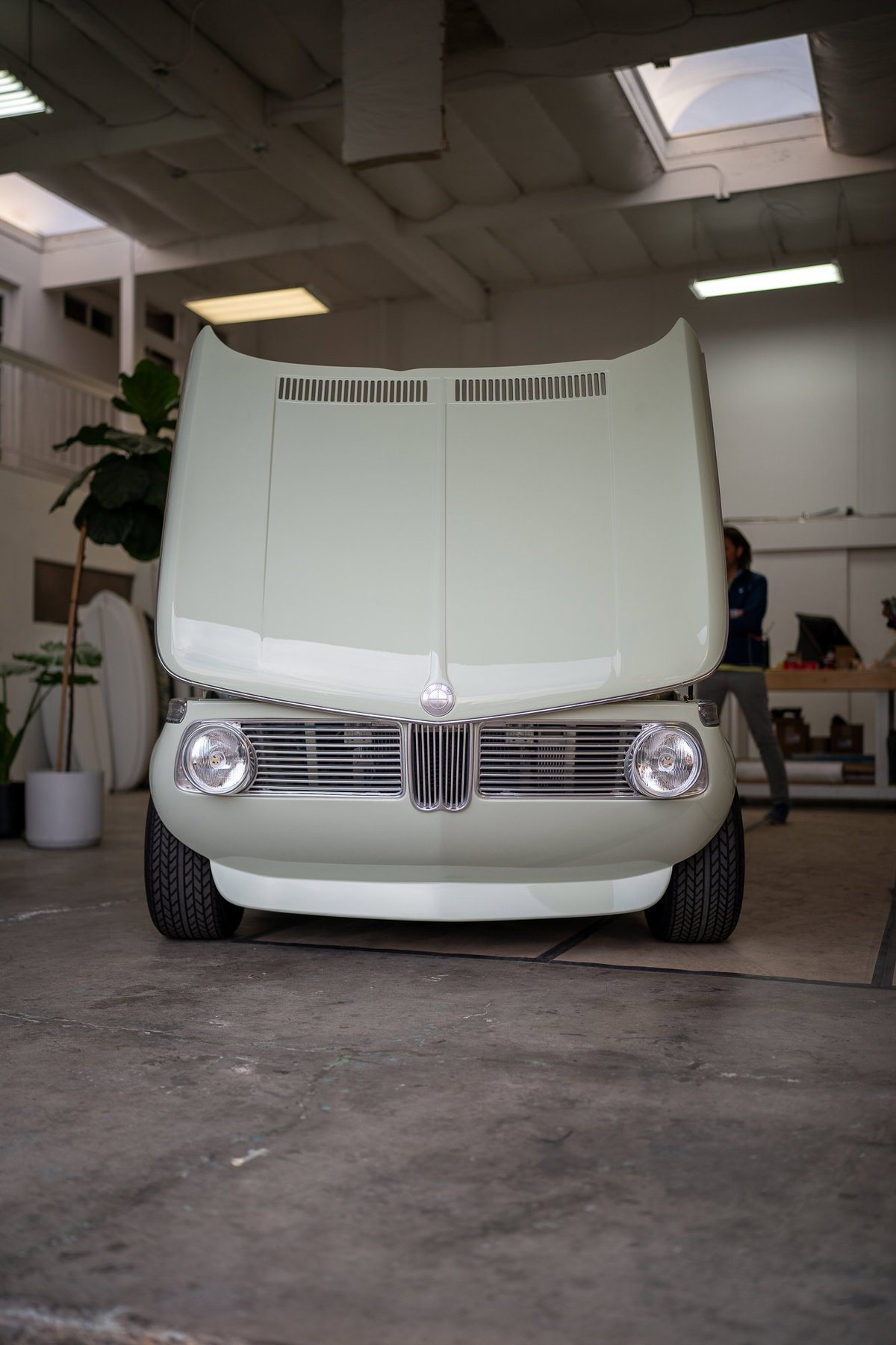 BMW 2002 Turbo in light green with hood open, showing vented hood panels.