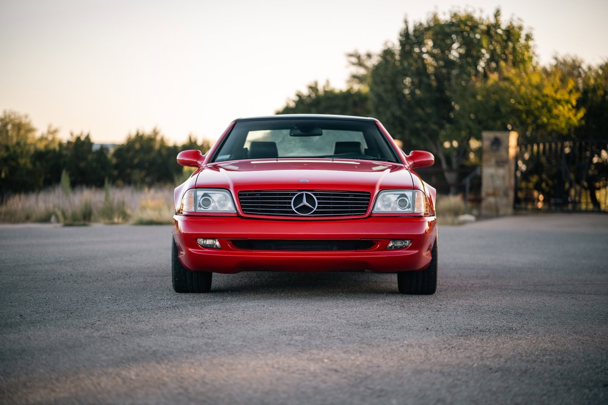 A front-facing red 2001 Mercedes-Benz SL600 with black soft top and chrome trim.