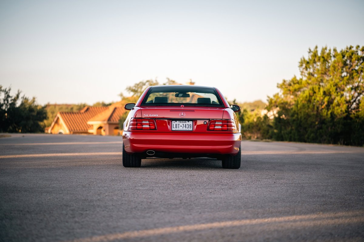 Rear view of a Magna Red 2001 Mercedes-Benz SL600 with chrome trim and alloy rims.