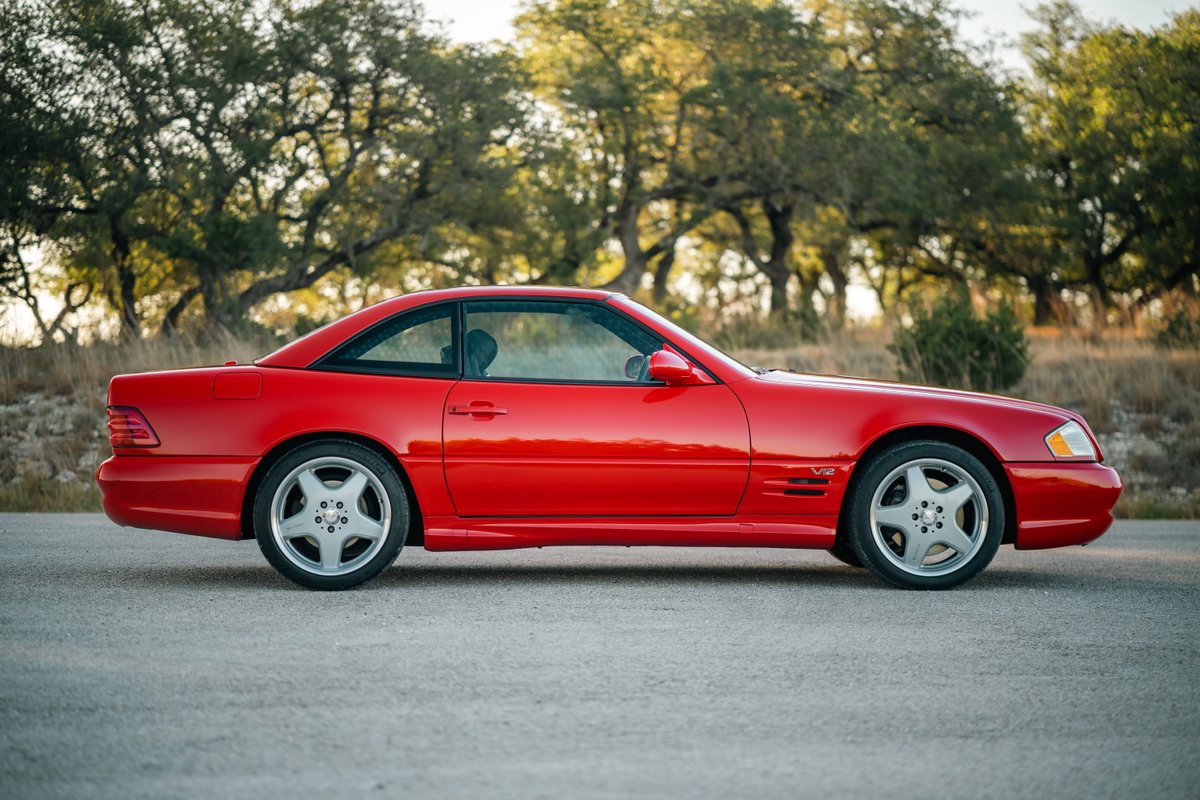 Red 2001 Mercedes-Benz SL600 coupe with five-spoke alloy rims and V12 badging.