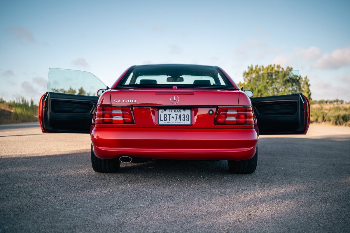 Rear view of a red 2001 Mercedes-Benz SL600 with doors open.
