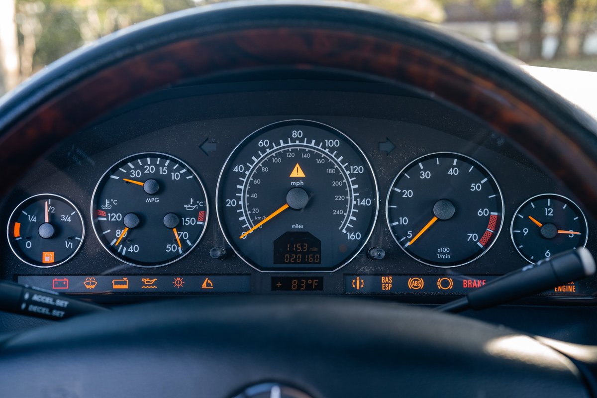 Dashboard of a 2001 Mercedes-Benz SL600 in Magna Red, showing gauges and warning lights.
