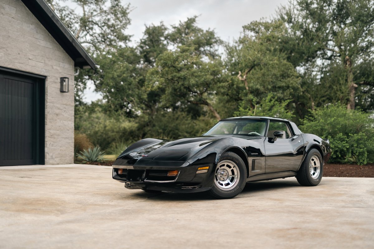 Black 1982 Chevrolet Corvette Stingray with factory alloy rims parked outdoors.