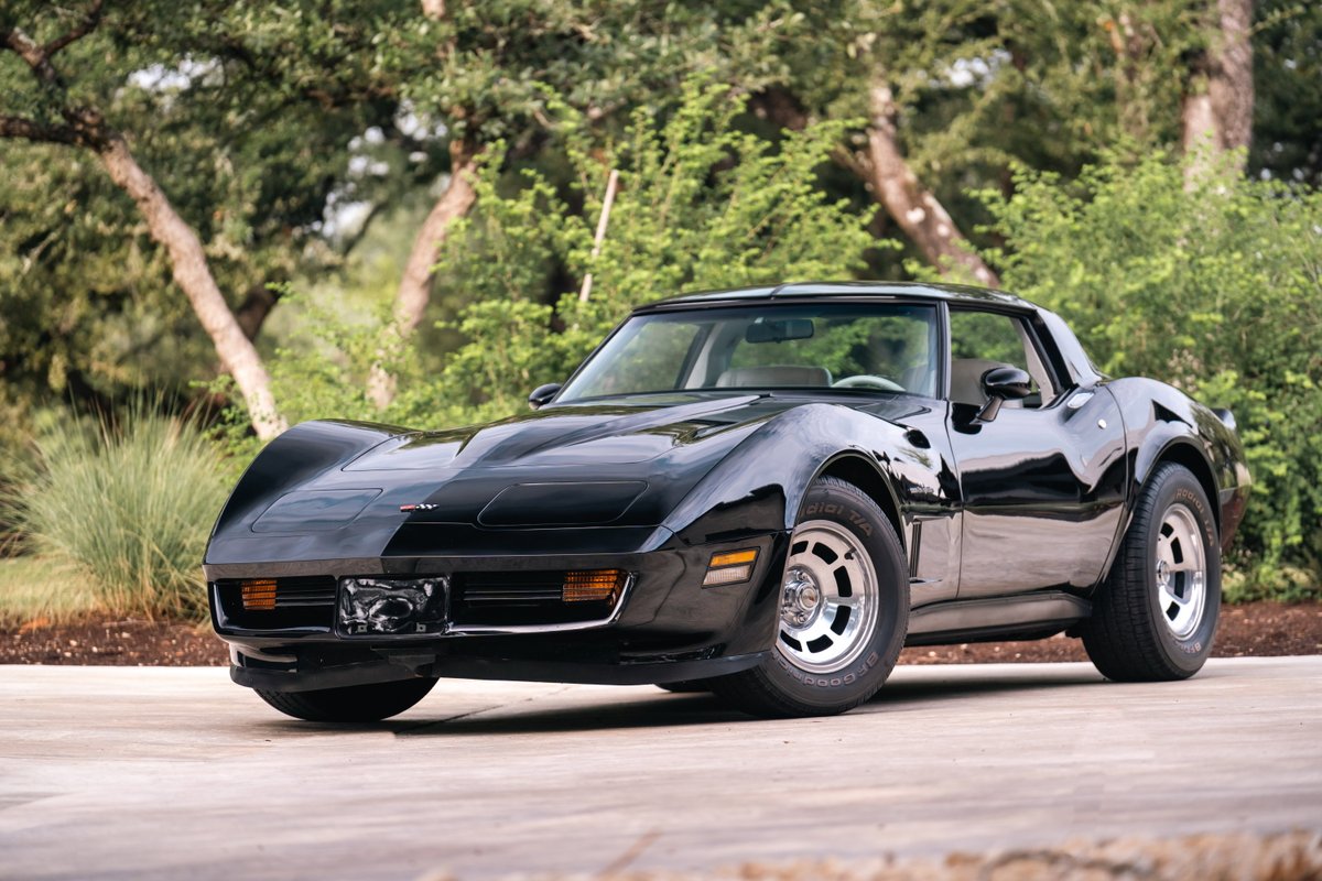 Black 1982 Chevrolet Corvette Stingray with silver rims parked outdoors.