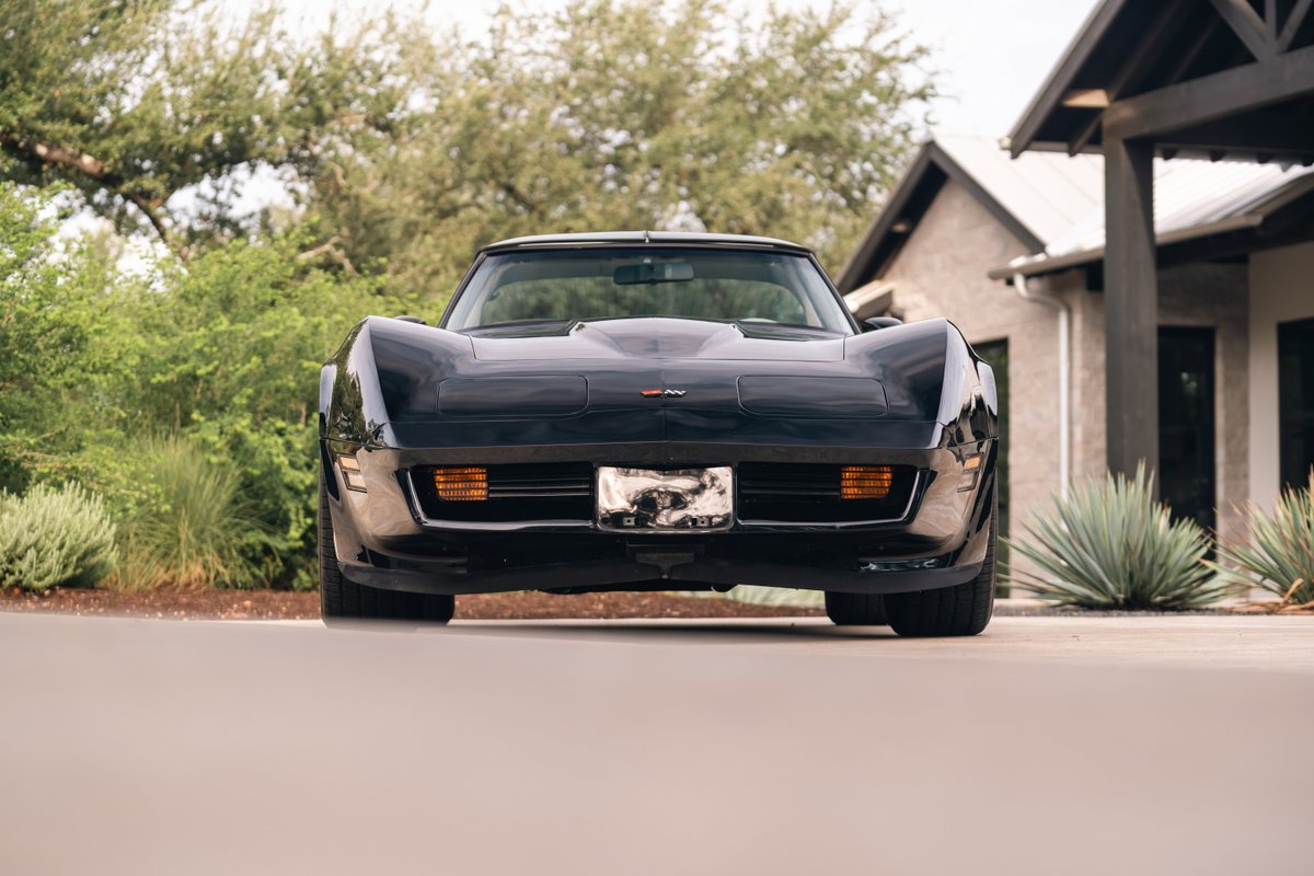 Front view of a black 1982 Chevrolet Corvette Stingray with chrome trim and stock rims.