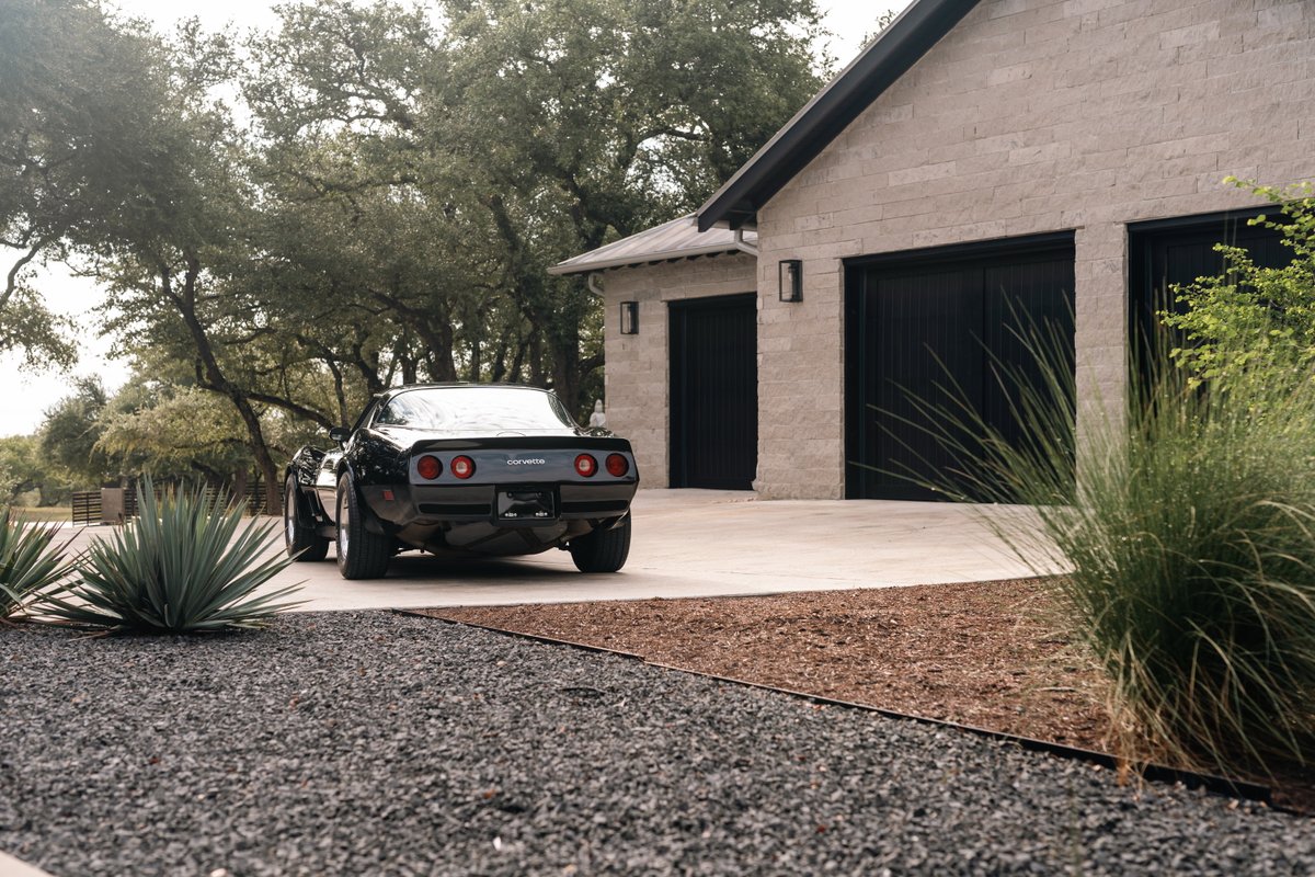 Black 1982 Chevrolet Corvette Stingray with quad taillights and chrome trim.