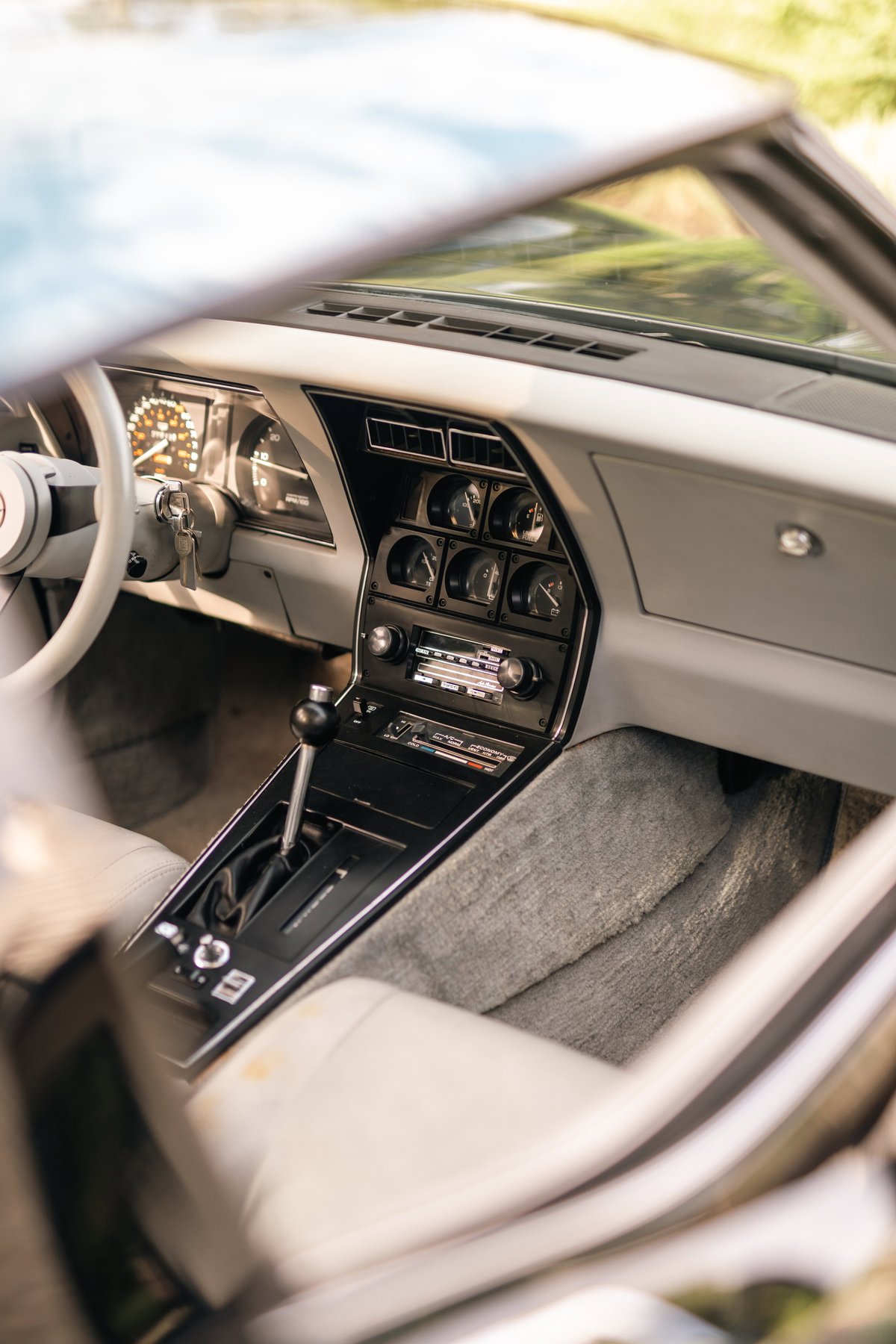 Interior view of a 1982 Chevrolet Corvette Stingray, showing the dashboard, shifter, and gauges.