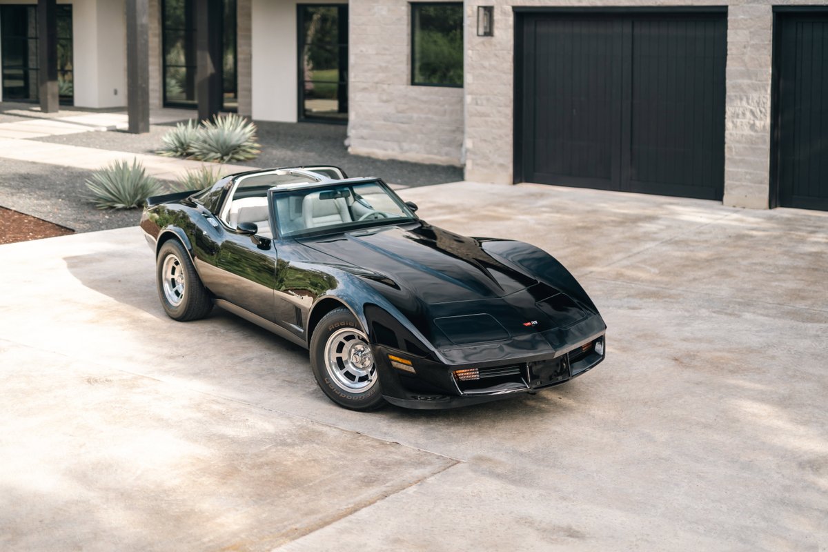 Black 1982 Chevrolet Corvette Stingray T-top with silver alloy rims and chrome trim.