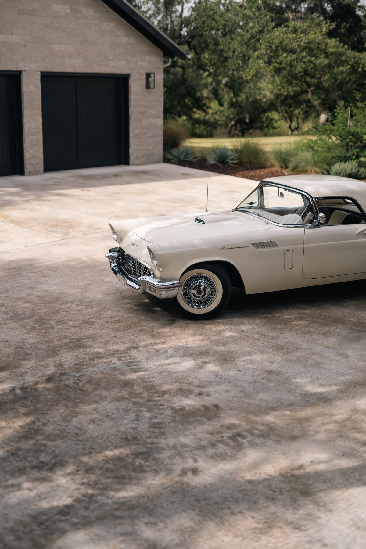 A colonial white 1957 Ford Thunderbird convertible with wire wheel rims.