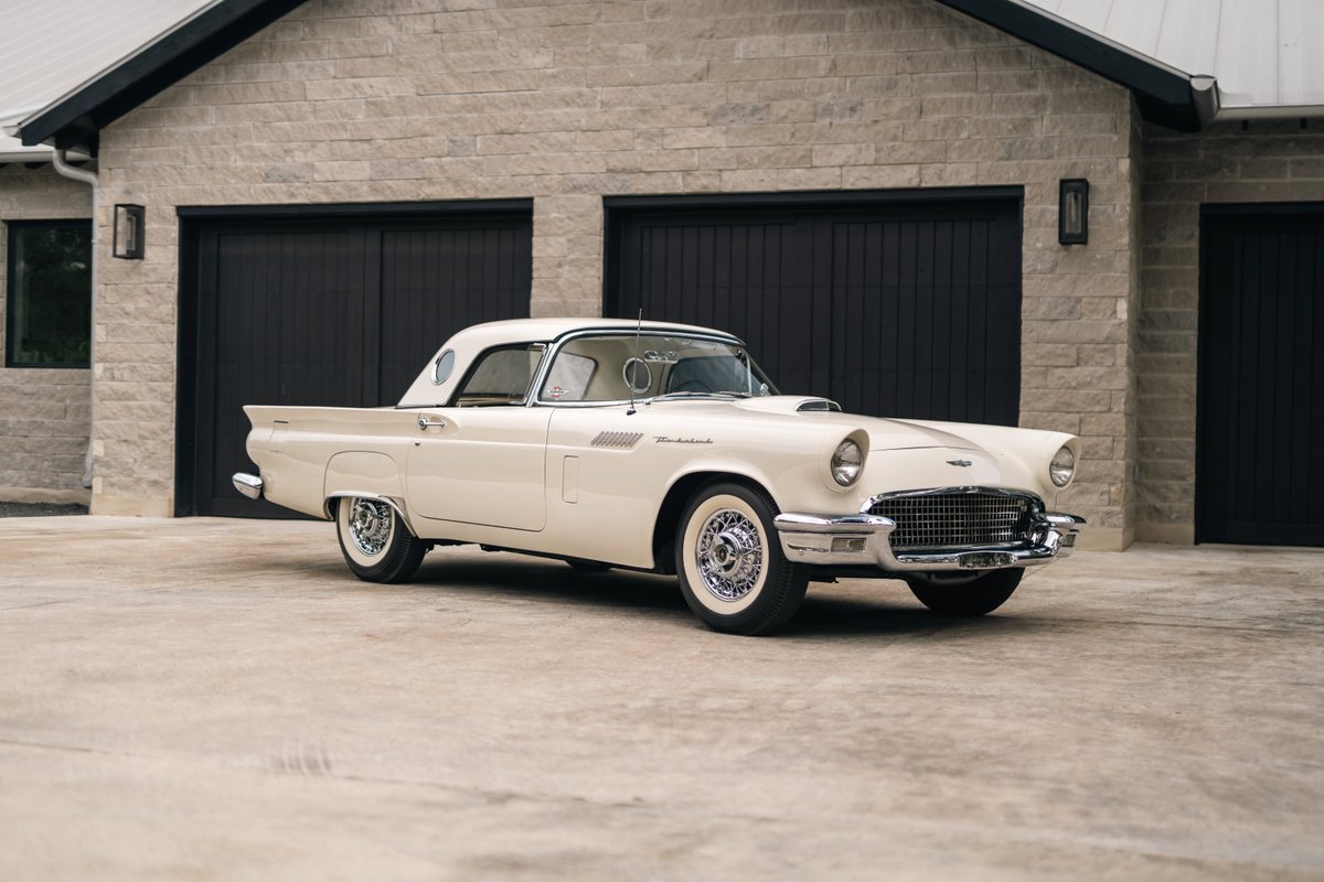 A colonial white 1957 Ford Thunderbird with classic chrome trim and whitewall tires.