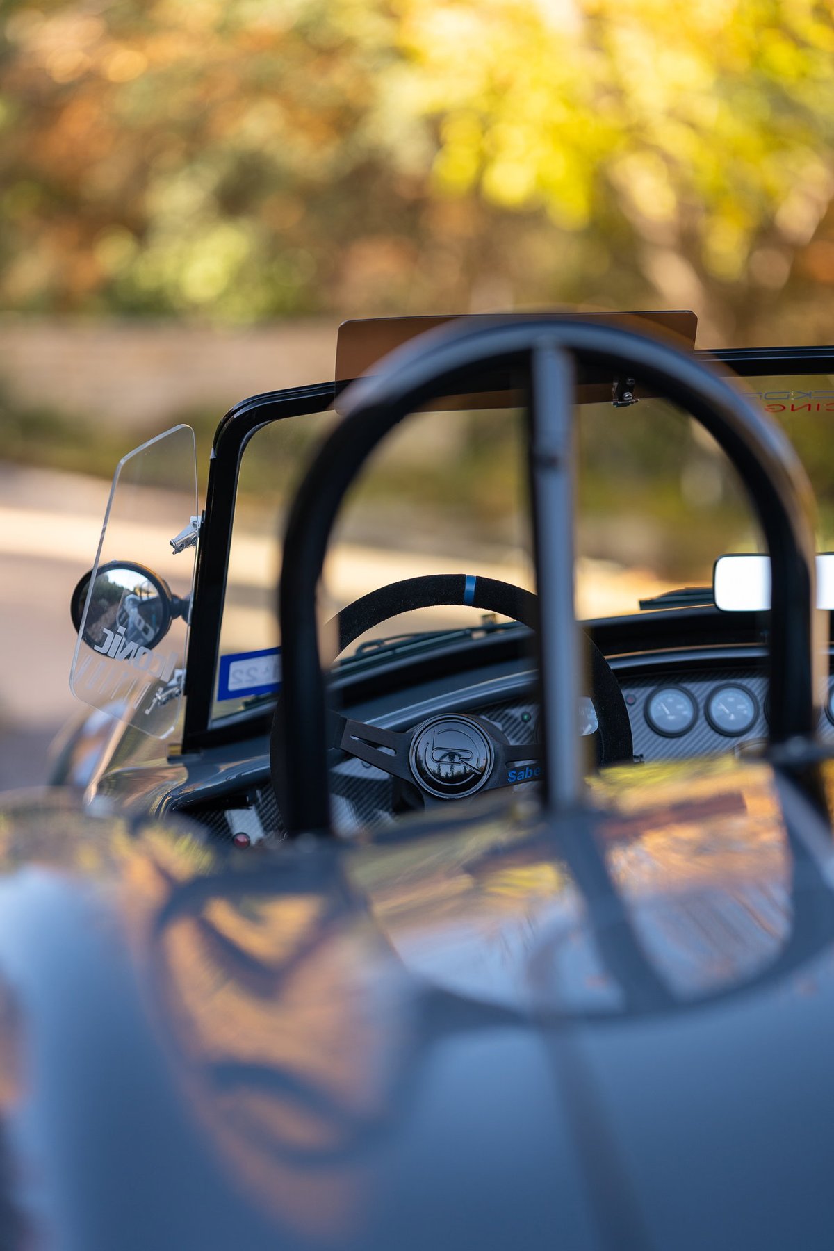 Close-up of a 1965 Backdraft Cobra's dashboard, showcasing the steering wheel and gauges.