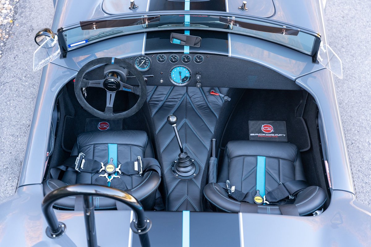 1965 Backdraft Cobra interior with racing seats, racing harnesses, and carbon fiber trim.