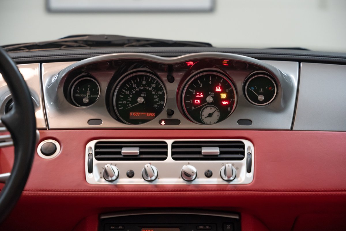 2002 BMW Z8 dashboard with red leather trim and silver accents.