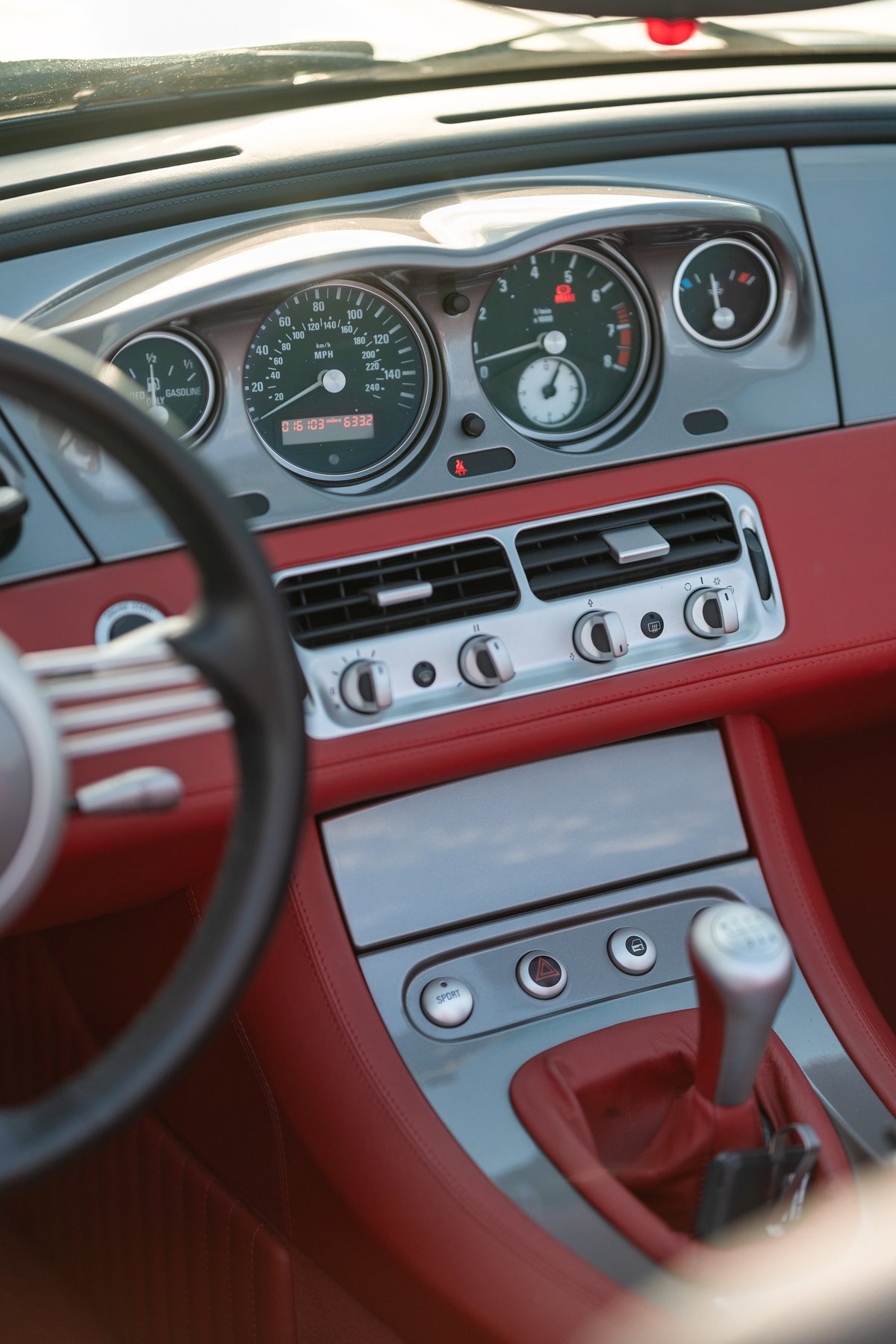 2002 BMW Z8 interior with red leather, silver trim, and classic gauges.