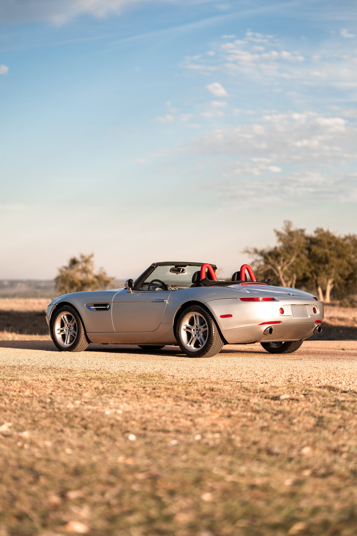 2002 BMW Z8 convertible in Titanium Silver with red roll hoops and multi-spoke rims.
