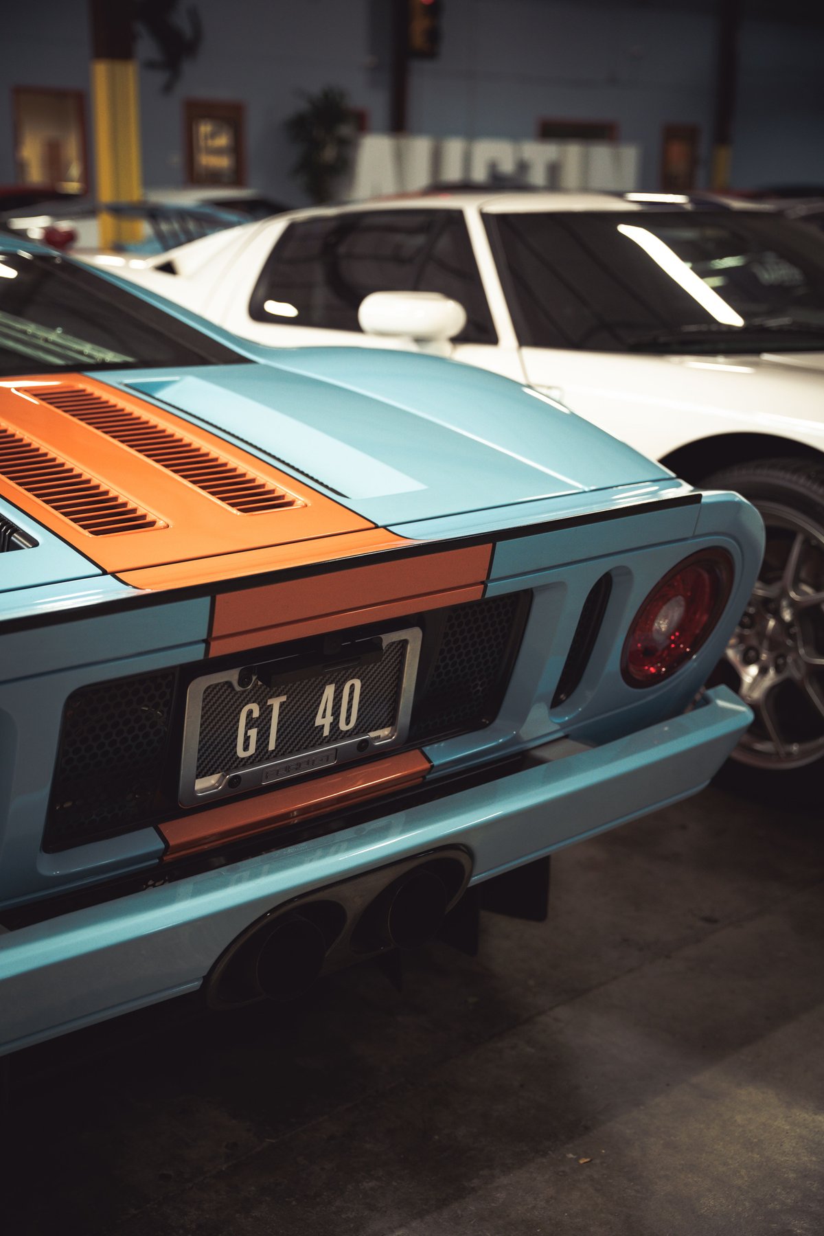 Rear view of a light blue and orange striped Ford GT40 with a "GT 40" license plate.