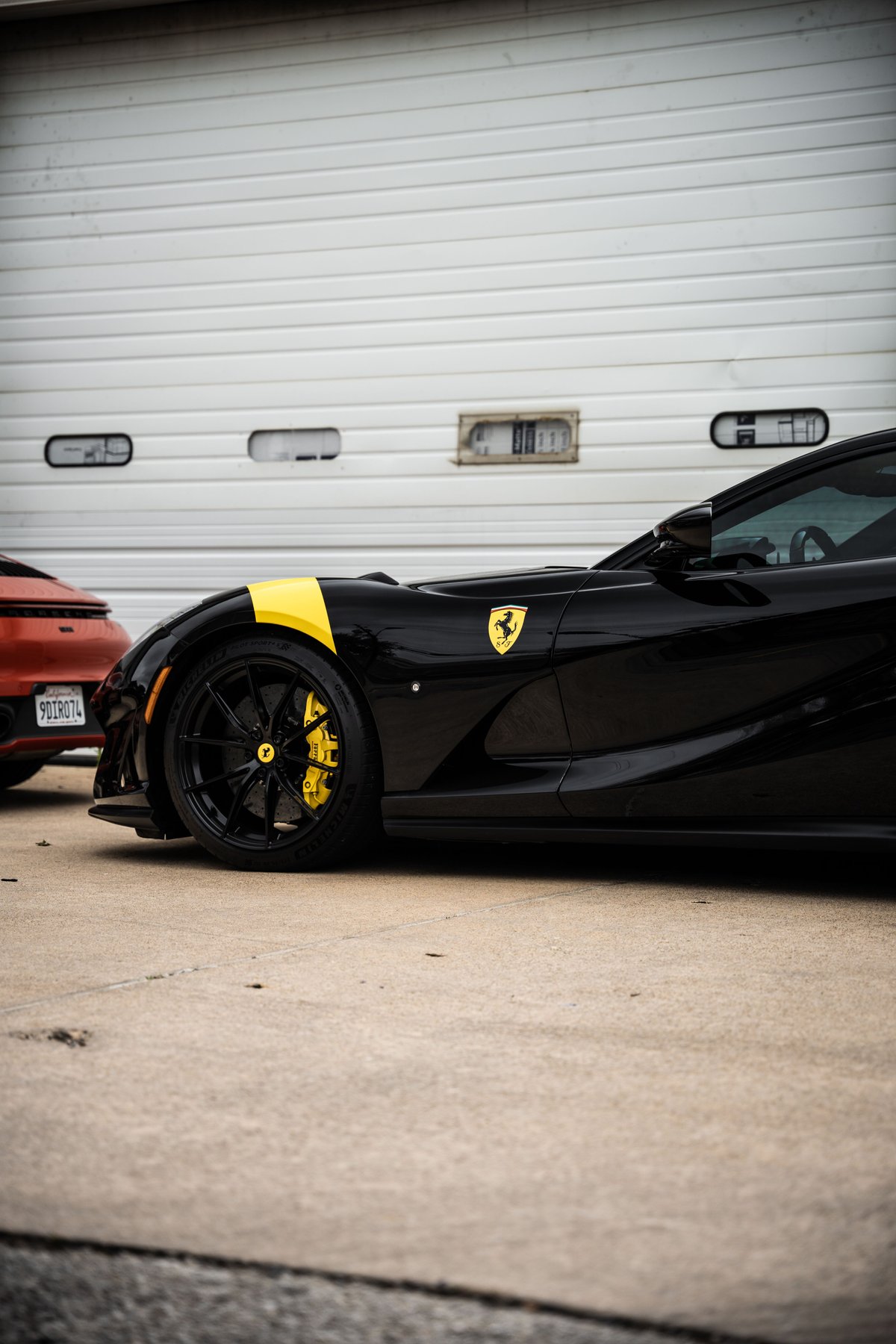 Black Ferrari with yellow livery stripe and brake calipers, black rims.