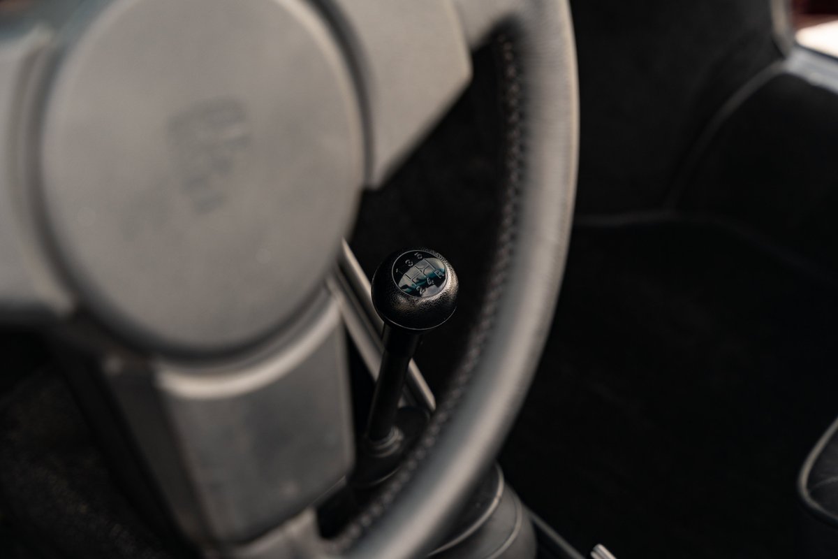 Close-up of a 1983 Porsche 911 SC Cabriolet's manual gear shifter and steering wheel.