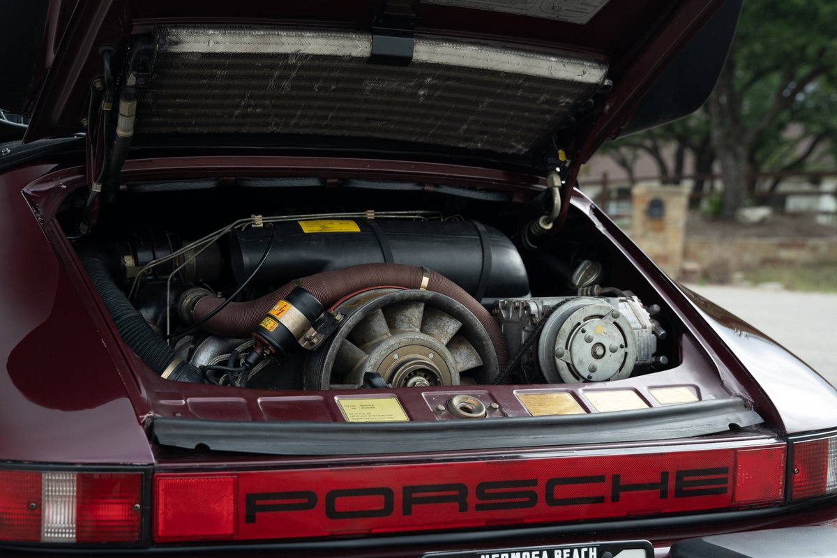 Rear view of a ruby red metallic 1983 Porsche 911SC Cabriolet engine bay.