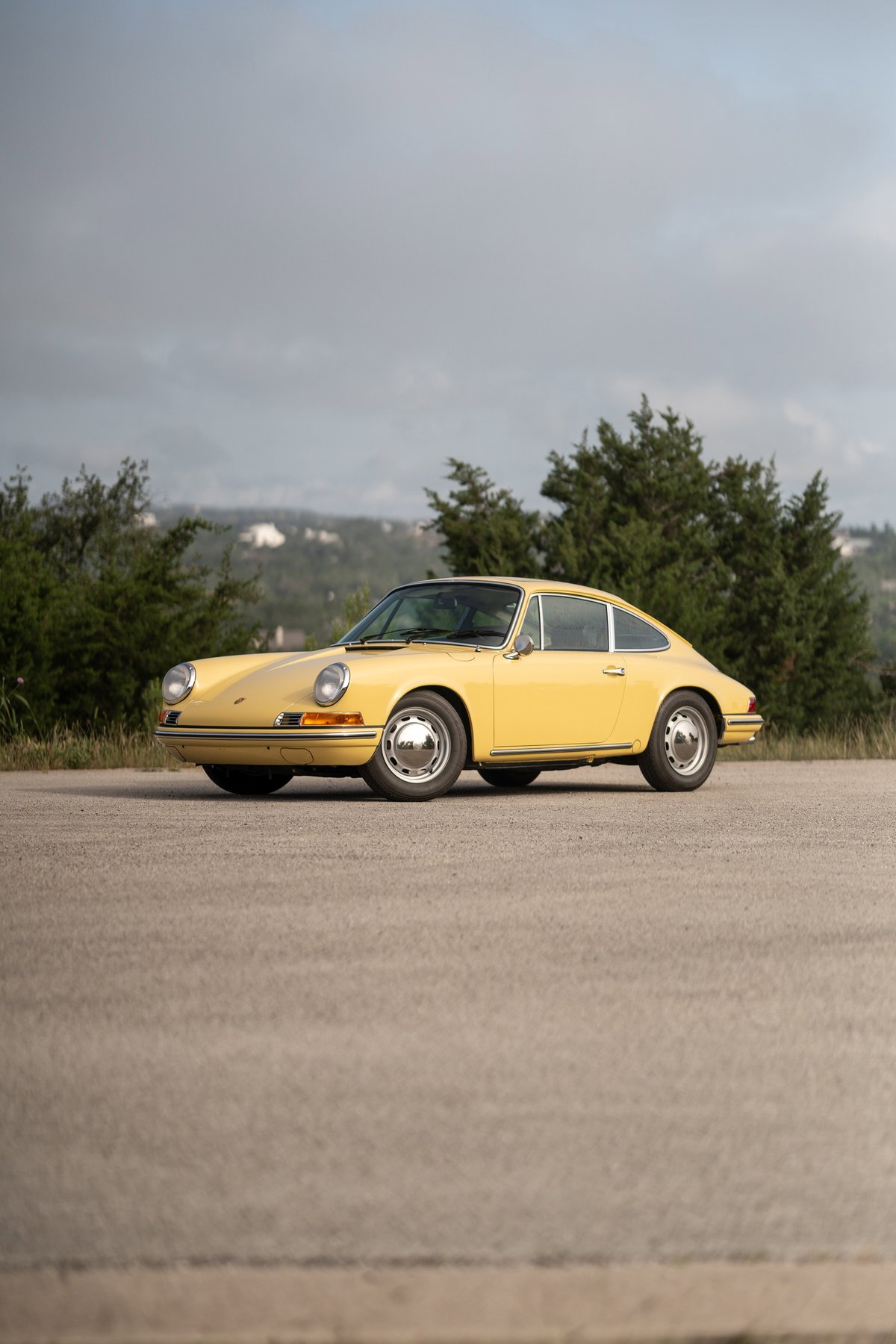 1969 Champagne Yellow Porsche 912 Coupe with chrome hubcaps and trim.