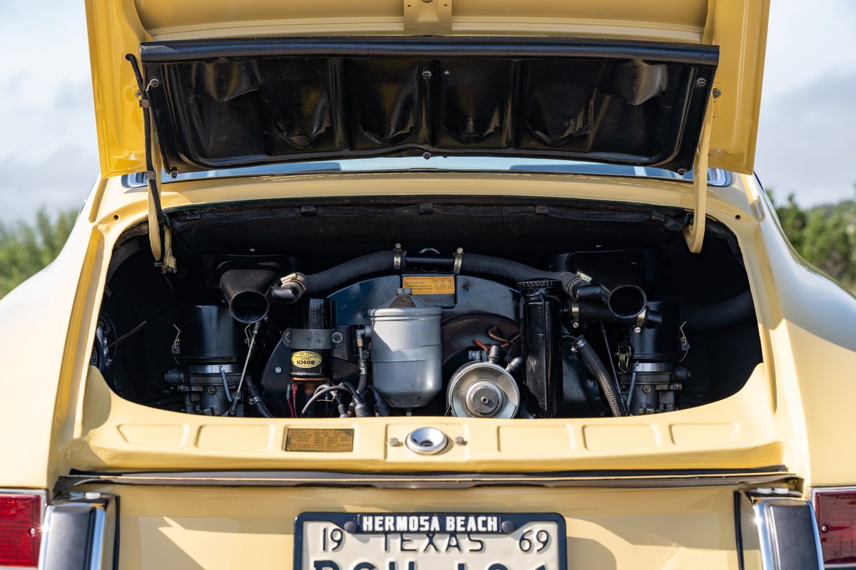 Rear view of a champagne yellow 1969 Porsche 912 coupe engine bay.