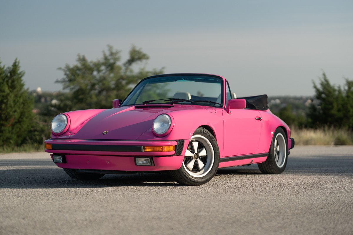 Pink Porsche 911 Carrera convertible with Fuchs rims and black trim.