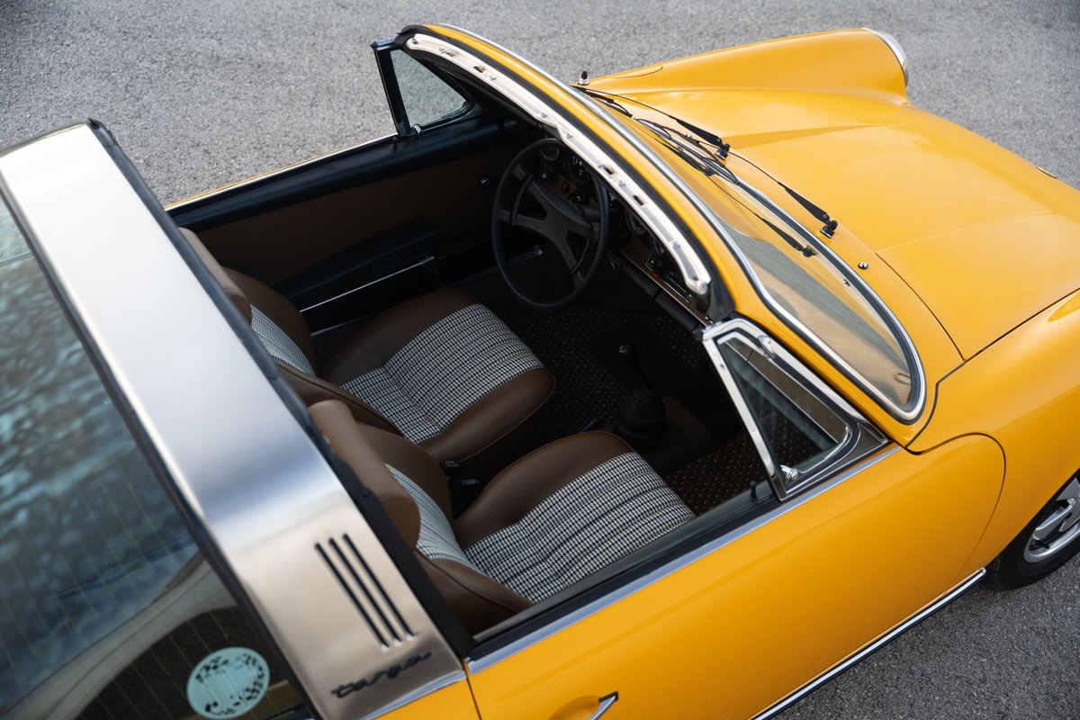 Signal Yellow 1973 Porsche 911S Targa interior, featuring striped fabric and brown leather seats.