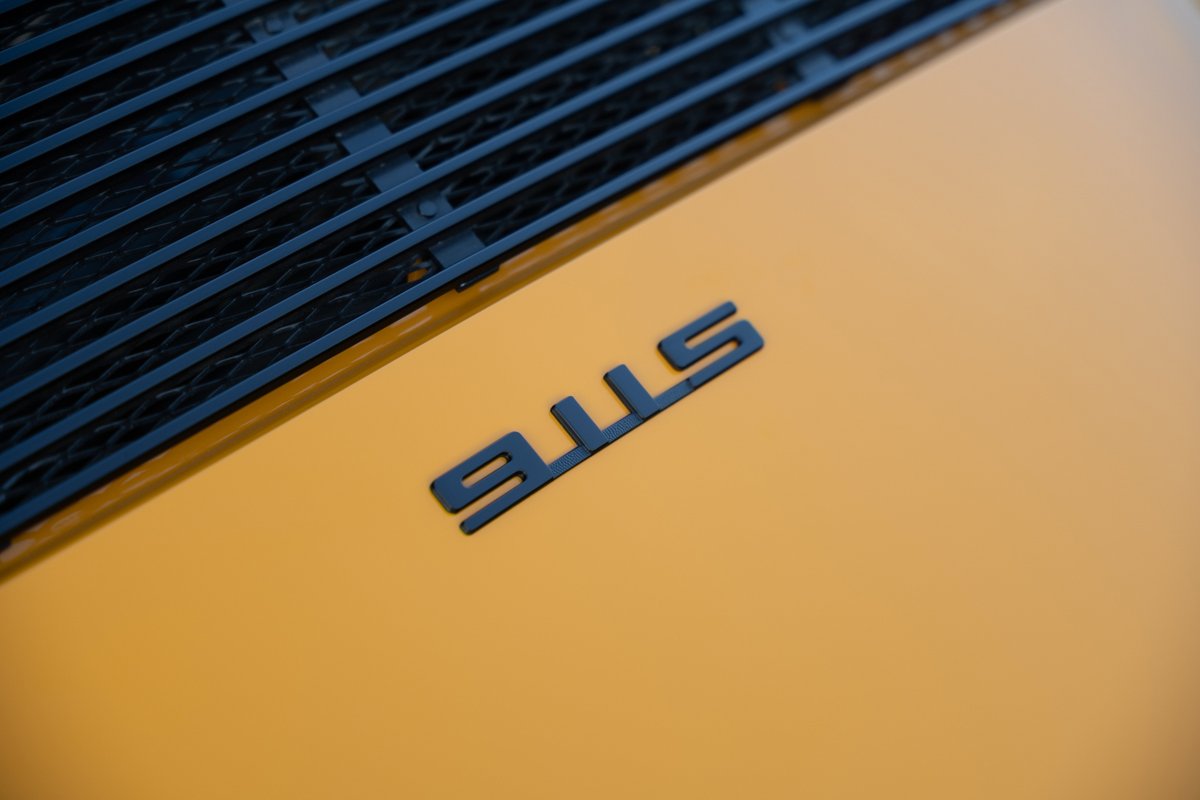 Black "911S" badge on signal yellow body of a 1973 Porsche 911S Targa.