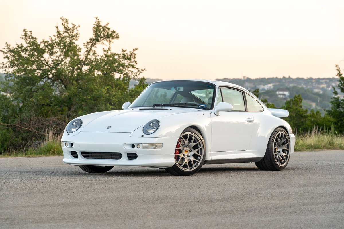 1997 Porsche 993 C4S in Glacier White with silver multi-spoke rims and red brake calipers.
