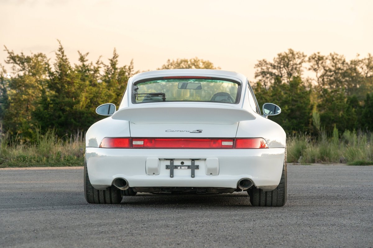 1997 Porsche 993 C4S in Glacier White, rear view, wide body, dual exhaust tips, spoiler.