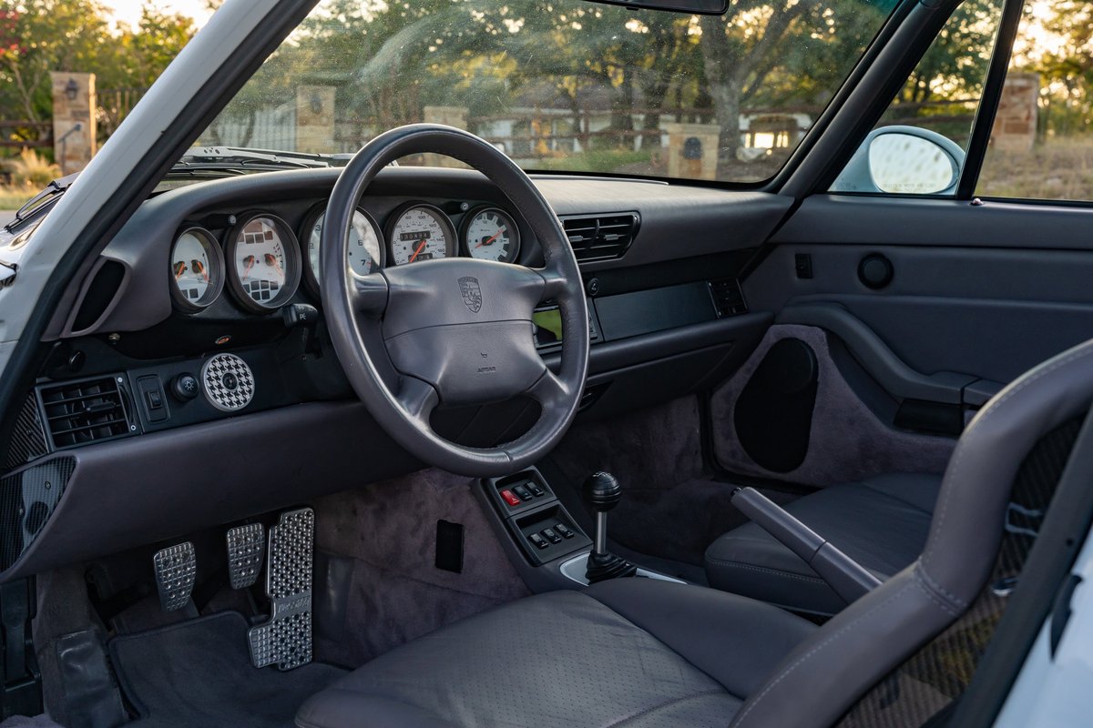 1997 Porsche 993 C4S interior: gray leather, five-gauge cluster, checkered vent trim, alloy pedals.