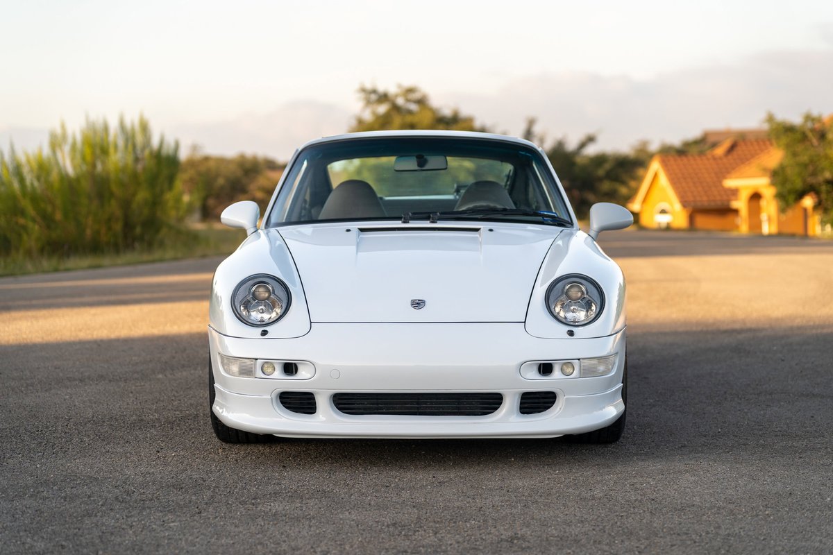 Front view of a white 1997 Porsche 993 C4S, showcasing its iconic headlights and bumper trim.