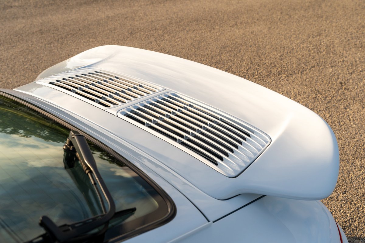 White 1997 Porsche 993 C4S with rear spoiler and engine grille.