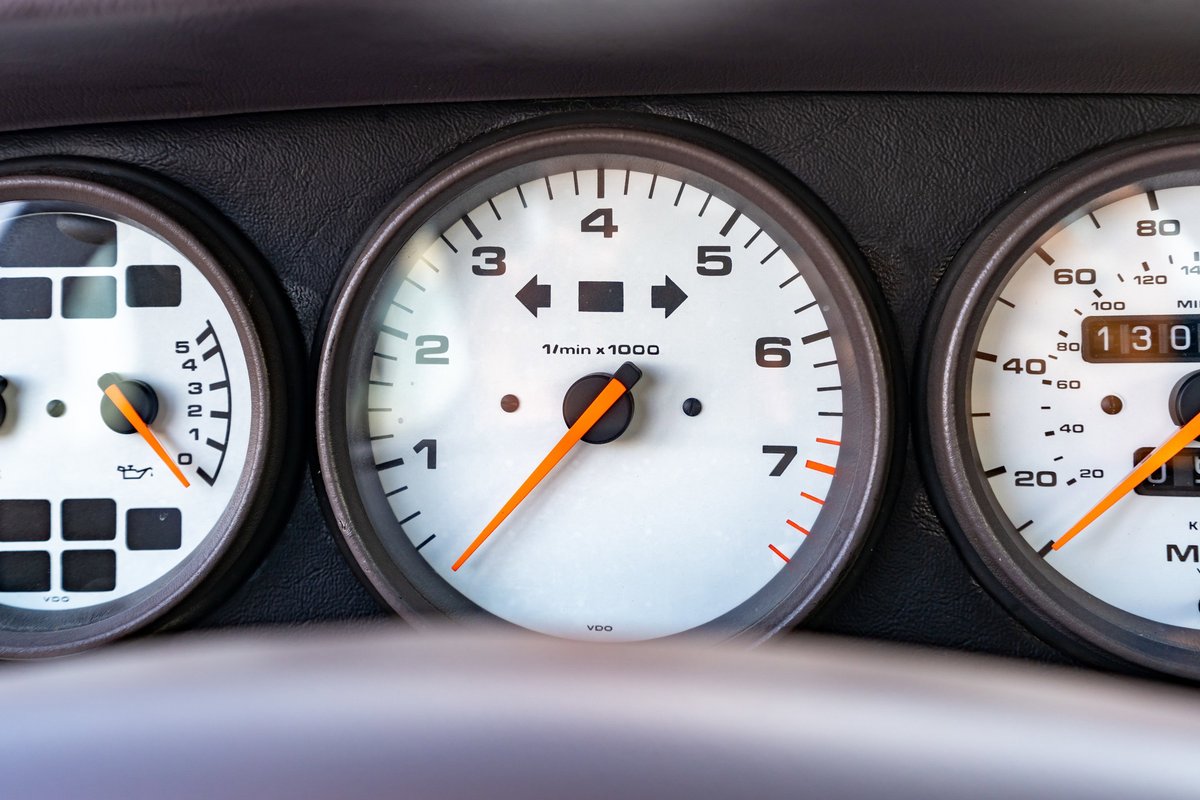 Close-up of the white tachometer and speedometer gauges in a 1997 Porsche 993 C4S.