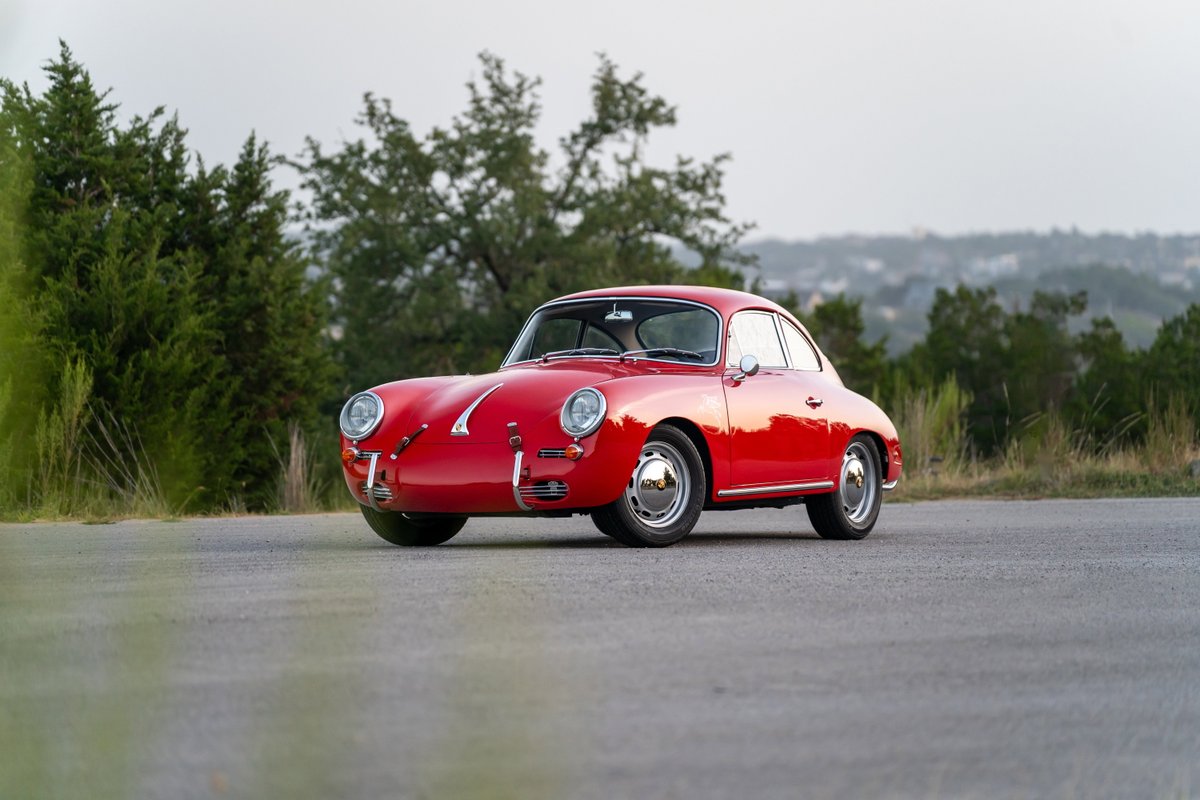 A red 1965 Porsche 356C with chrome trim and hubcap rims.