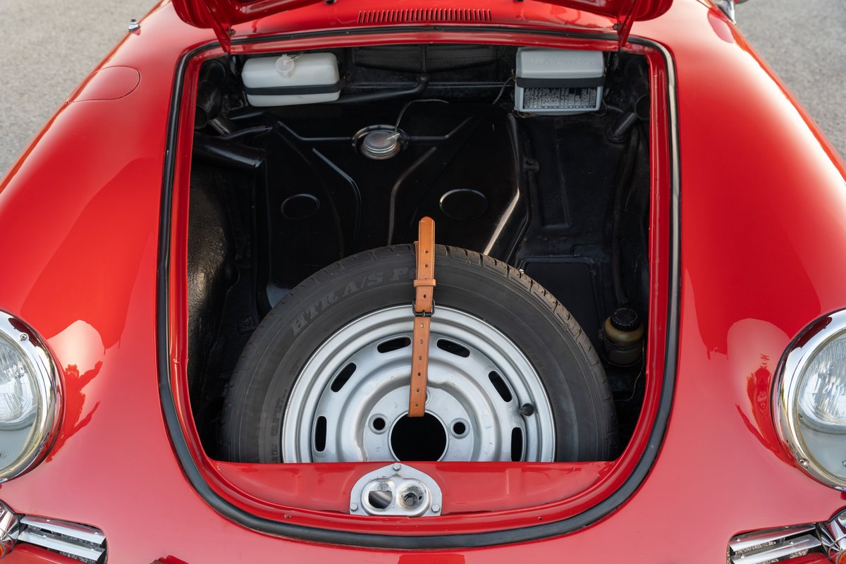 1965 Porsche 356C in Signal Red with spare tire and silver rim in front trunk.