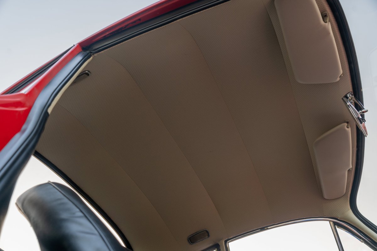 Interior shot of a 1965 Porsche 356C with beige headliner and sun visors.