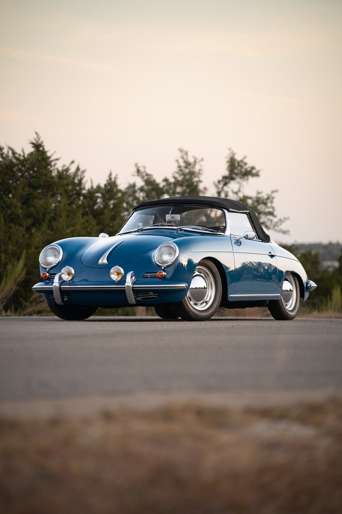 Front view of a royal blue 1960 Porsche 356B Roadster with chrome hubcaps and detailing.