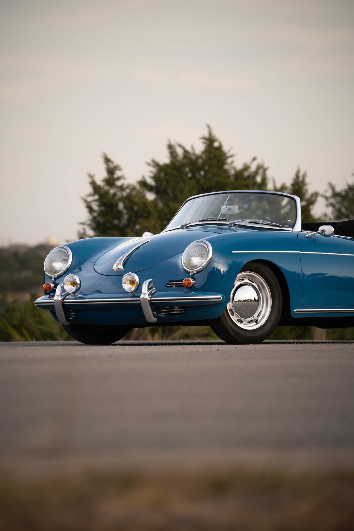 Blue 1960 Porsche 356B Roadster with chrome hubcaps and brightwork trim.