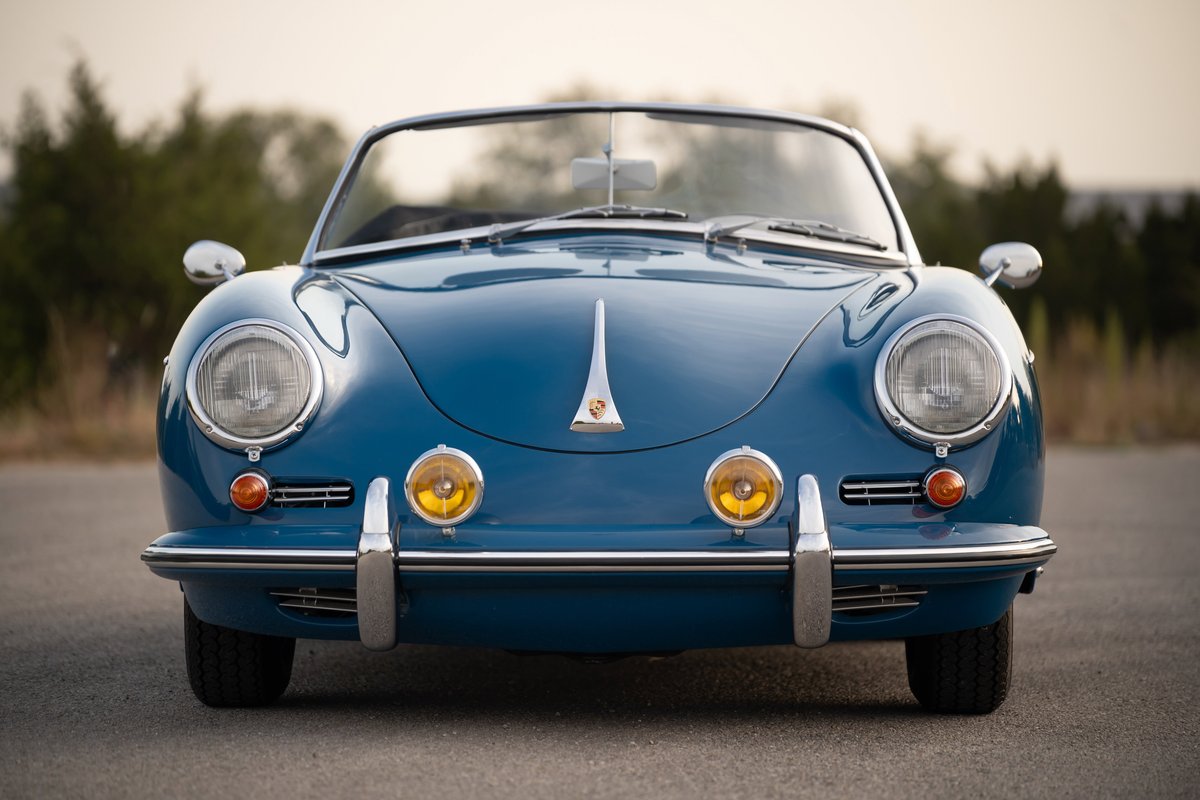 Front view of a royal blue 1960 Porsche 356B Roadster, showcasing its iconic round headlights.