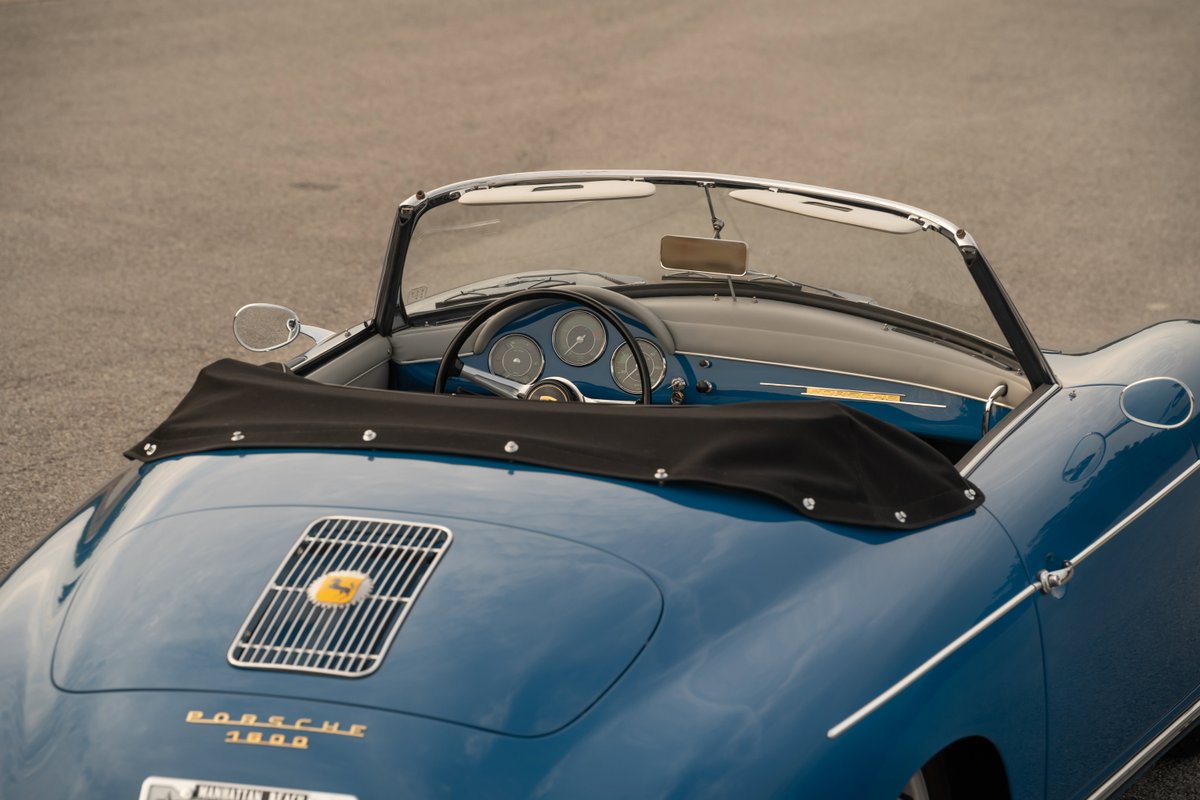 Blue 1960 Porsche 356B Roadster with classic instrument cluster and black tonneau cover.