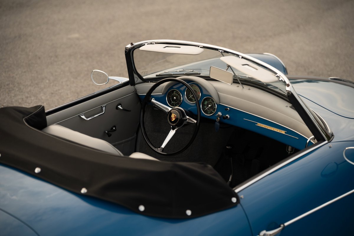 Close-up interior shot of a royal blue 1960 Porsche 356B Roadster dashboard and driver's side.