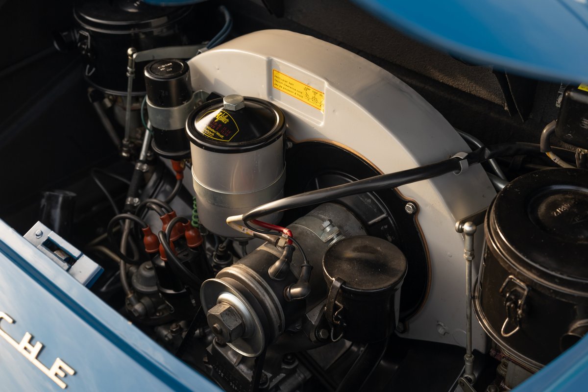 Close-up of a royal blue 1960 Porsche 356B engine bay, showing the fan shroud and cooling system.
