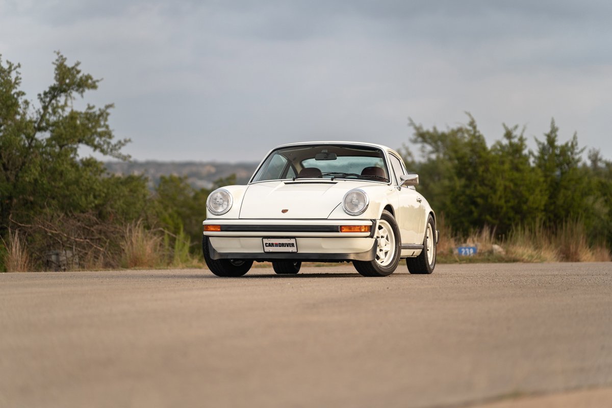 White 1974 Porsche 911 Coupe with chrome trim and Fuchs wheels.