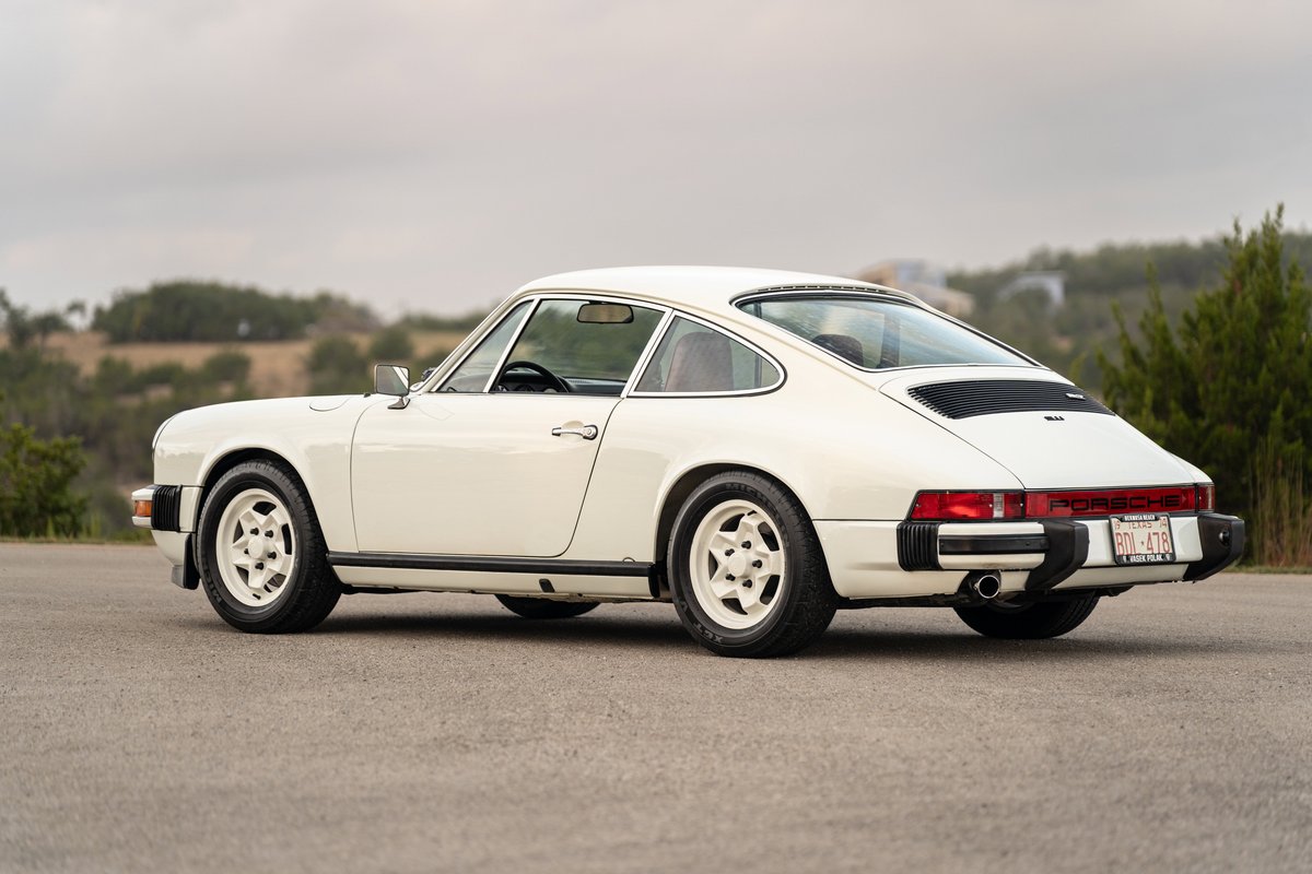 1974 Porsche 911 coupe in Grand Prix white, featuring Fuchs rims and black trim.