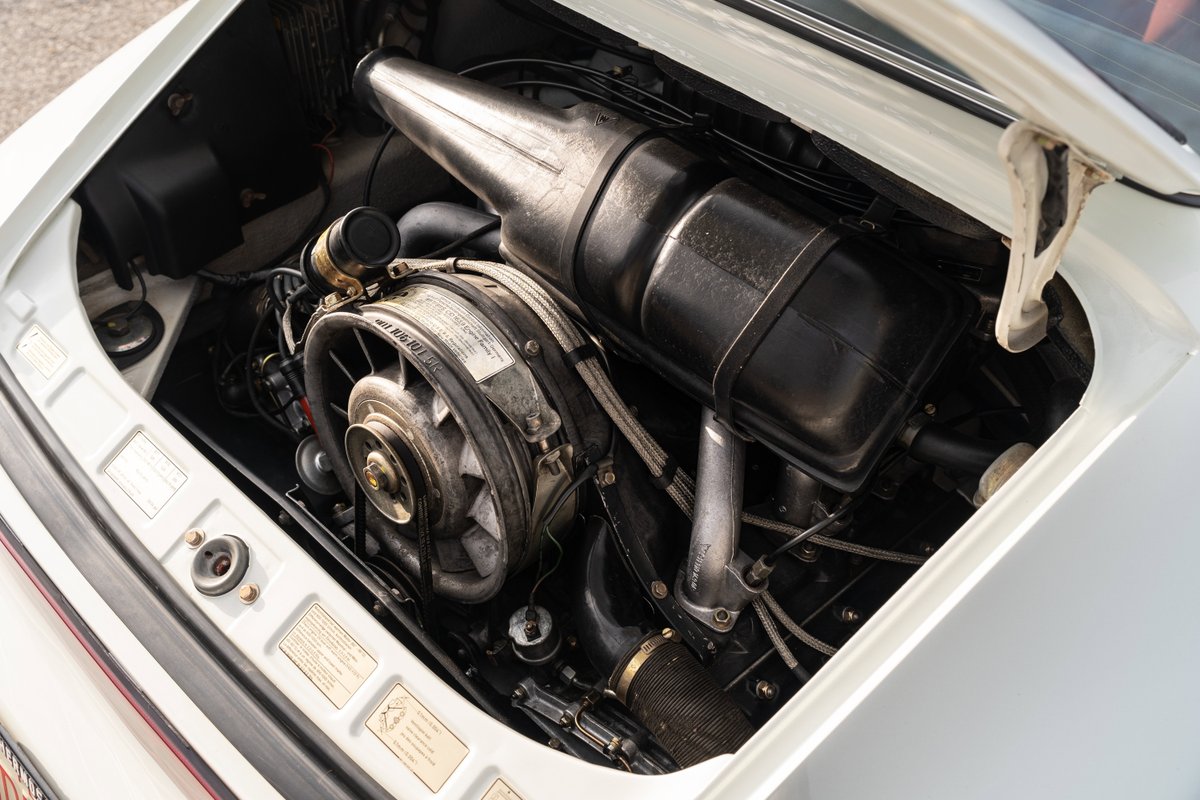 Close-up of a 1974 Porsche 911 coupe's air-cooled flat-six engine.